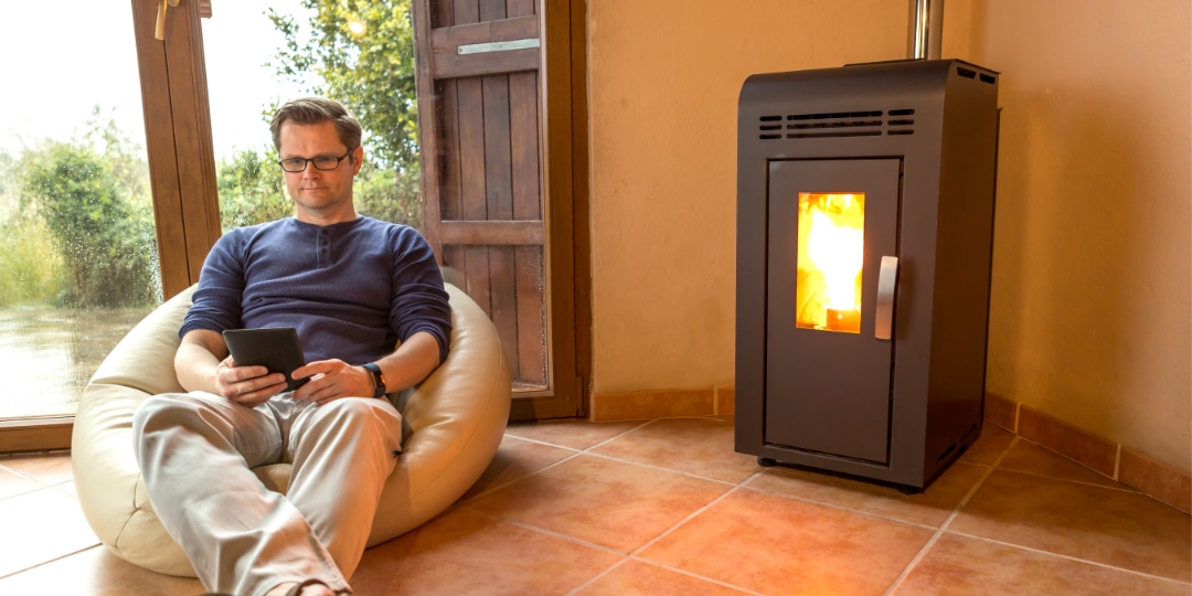 homme qui lit devant sont poêle à granulés pellets